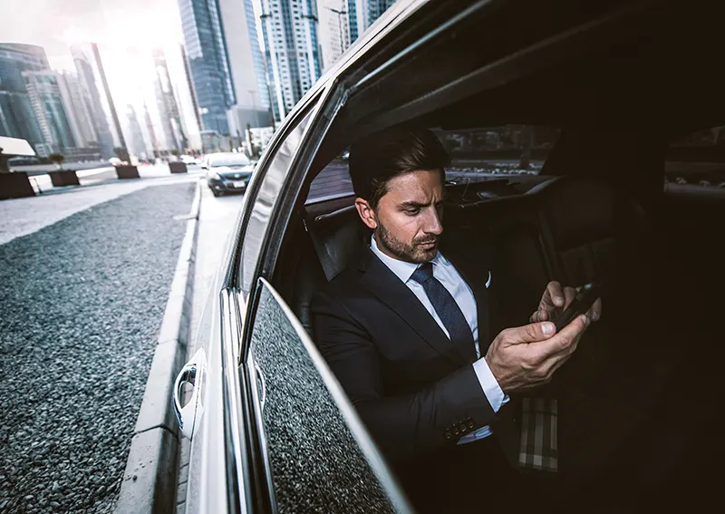 businessman texting on mobile while driving