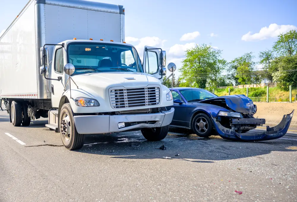 Collision of a semi truck with box trailer a passenger car on the highway road