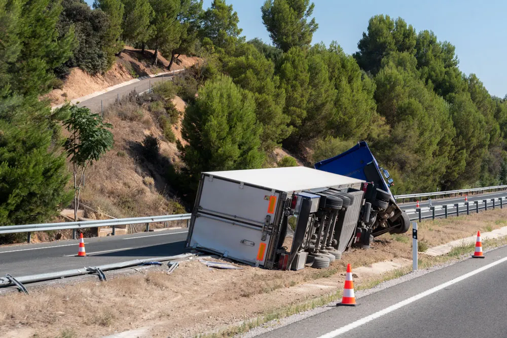 Truck with an accident refrigerated semi-trailer, overturned by the exit of the highway in the median of the highway.